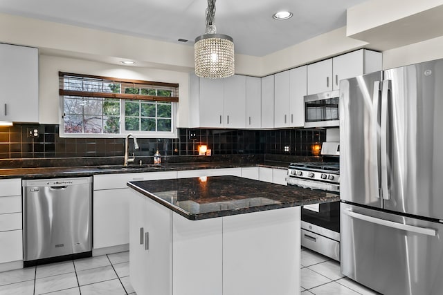 kitchen featuring a kitchen island, decorative light fixtures, white cabinetry, sink, and stainless steel appliances