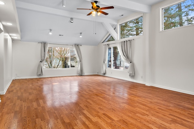 interior space featuring ceiling fan, hardwood / wood-style floors, and vaulted ceiling with beams