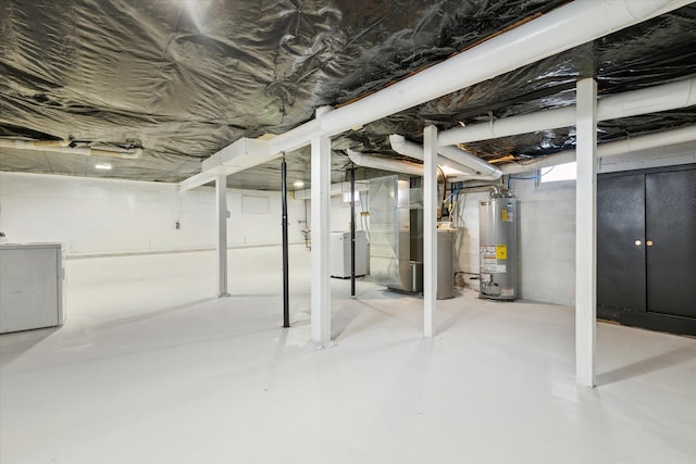 basement featuring heating unit, washer / dryer, and water heater