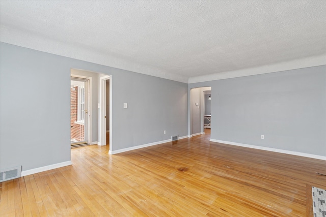 empty room featuring wood-type flooring and a textured ceiling