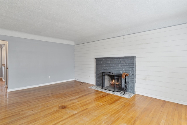 unfurnished living room featuring a textured ceiling, a fireplace, and wood-type flooring