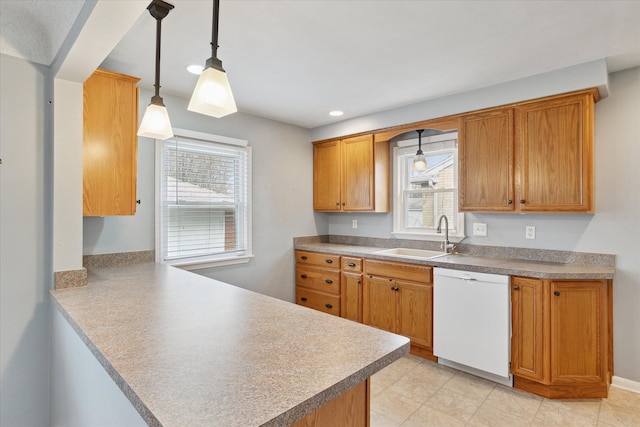 kitchen featuring pendant lighting, sink, white dishwasher, kitchen peninsula, and plenty of natural light