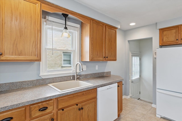 kitchen with sink, white appliances, and hanging light fixtures