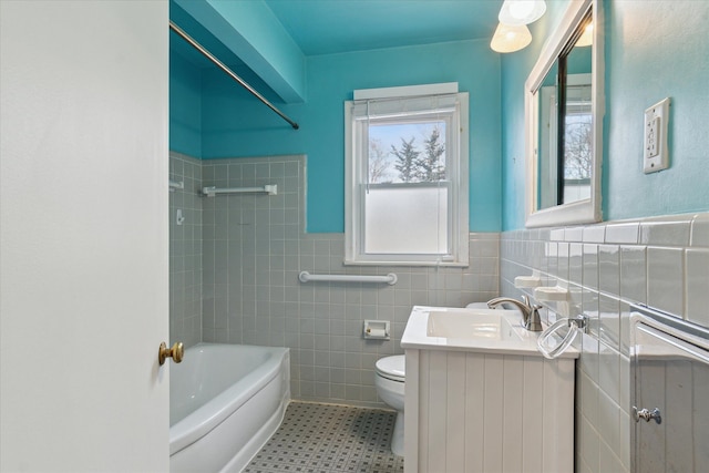 full bathroom with vanity, tiled shower / bath, tile walls, and toilet