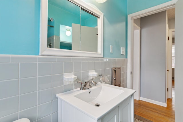 bathroom with vanity, wood-type flooring, and tile walls