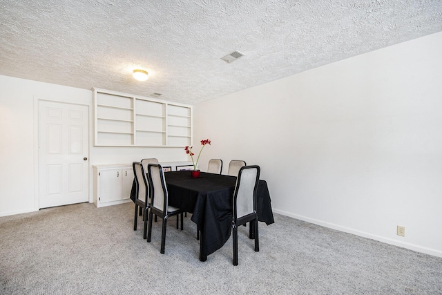 carpeted dining area featuring a textured ceiling