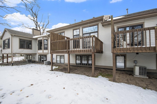 snow covered back of property featuring central AC