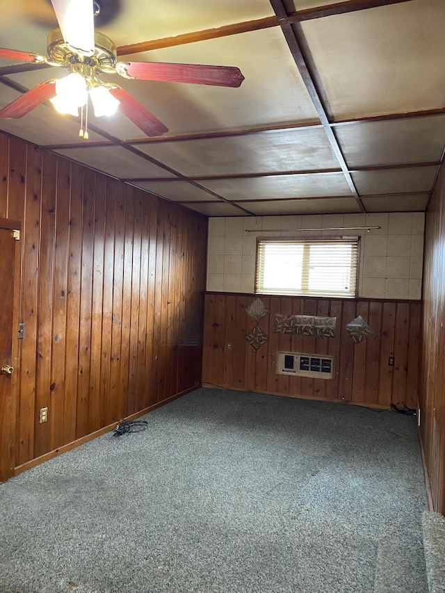 spare room featuring wooden walls, ceiling fan, and carpet