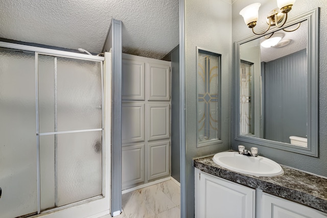 bathroom featuring vanity, a chandelier, an enclosed shower, and a textured ceiling