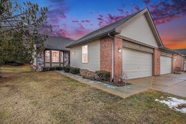 property exterior at dusk with a garage and a yard