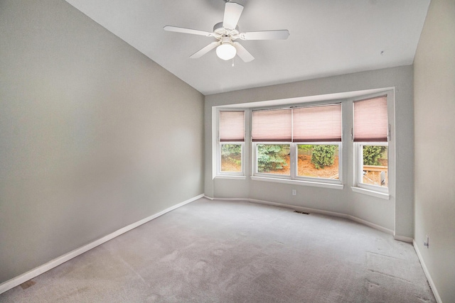 carpeted empty room with plenty of natural light, lofted ceiling, and ceiling fan