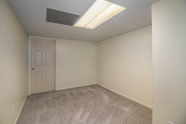 carpeted empty room with a drop ceiling