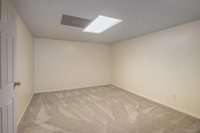 carpeted spare room featuring a paneled ceiling