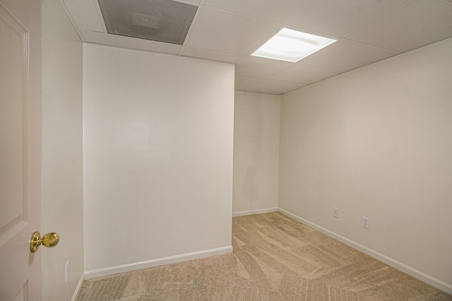 carpeted spare room with a drop ceiling