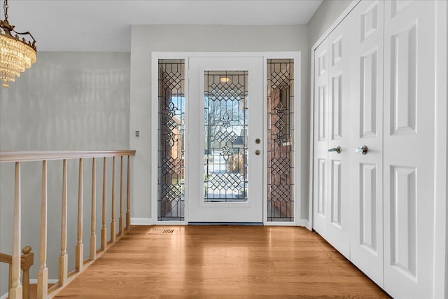 foyer entrance featuring light hardwood / wood-style flooring and a chandelier