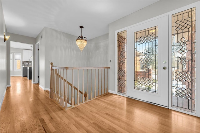 entrance foyer featuring light hardwood / wood-style flooring and a chandelier