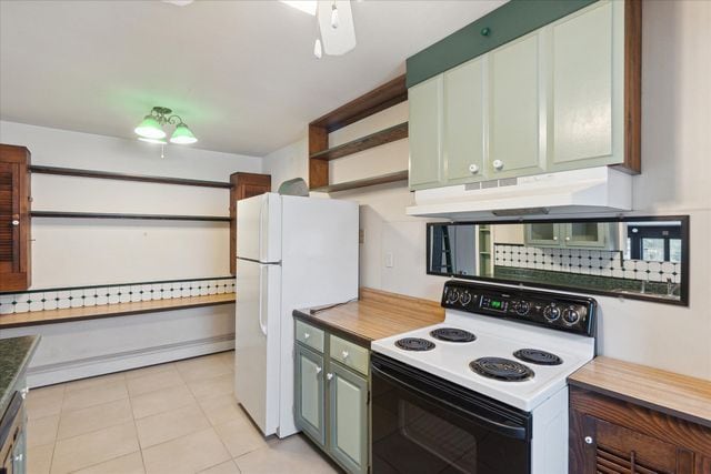 kitchen featuring tasteful backsplash, electric range oven, light tile patterned floors, and white refrigerator