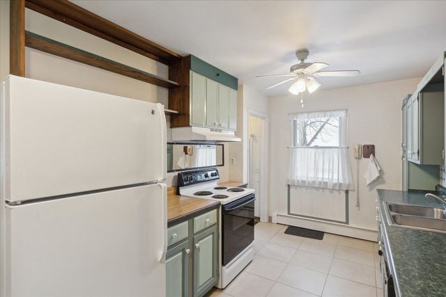 kitchen with ceiling fan, white appliances, green cabinets, and sink