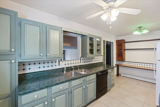 kitchen featuring sink, light tile patterned floors, black dishwasher, ceiling fan, and backsplash