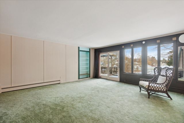 unfurnished room featuring baseboard heating and light colored carpet