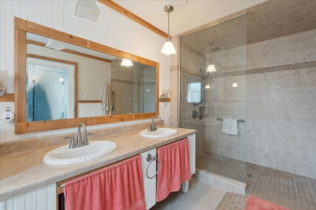 bathroom with vanity and tiled shower