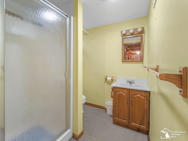 bathroom with vanity, a shower with shower door, and toilet