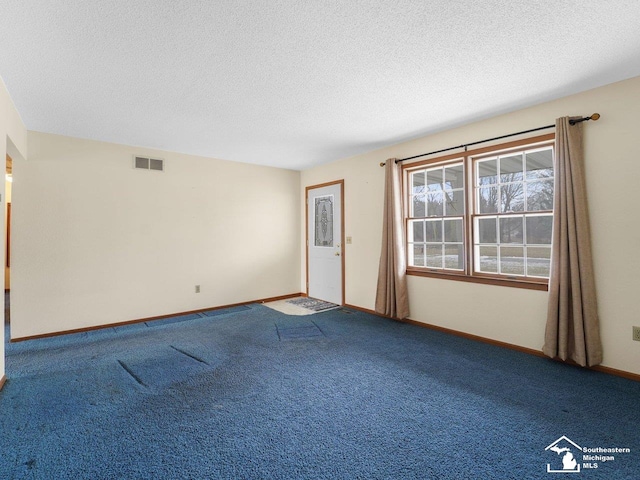 unfurnished room featuring carpet floors and a textured ceiling