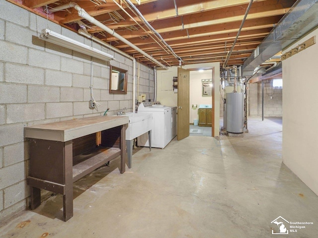 basement featuring water heater, washing machine and dryer, and sink