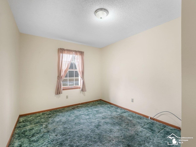 carpeted spare room with a textured ceiling