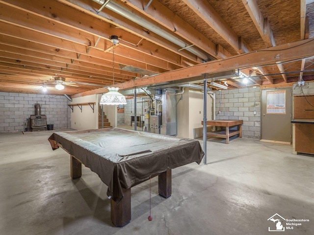 rec room with pool table, concrete floors, and a wood stove