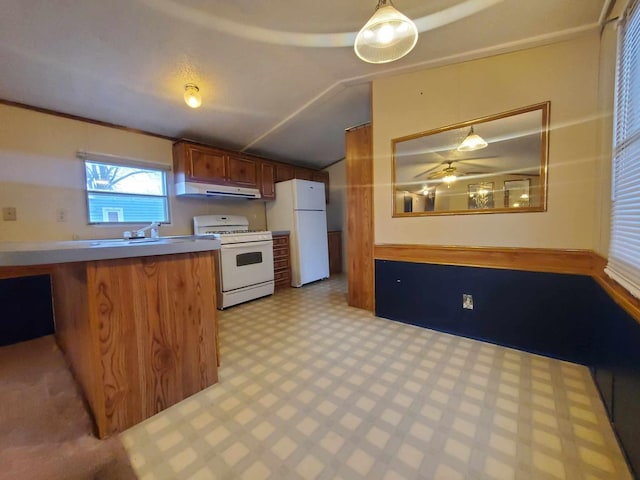 kitchen featuring hanging light fixtures, white appliances, vaulted ceiling, and sink