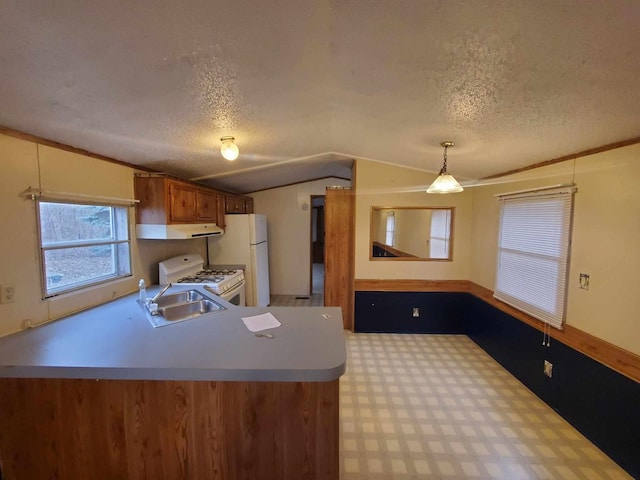 kitchen with vaulted ceiling, pendant lighting, sink, white appliances, and a textured ceiling