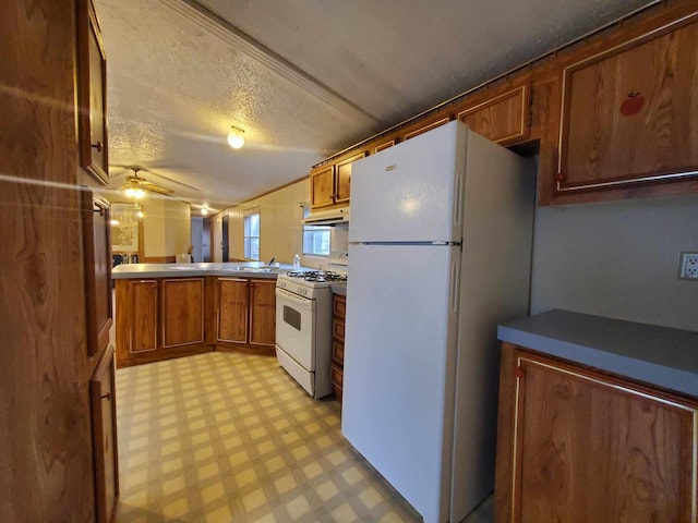 kitchen with ceiling fan, a textured ceiling, white appliances, and kitchen peninsula