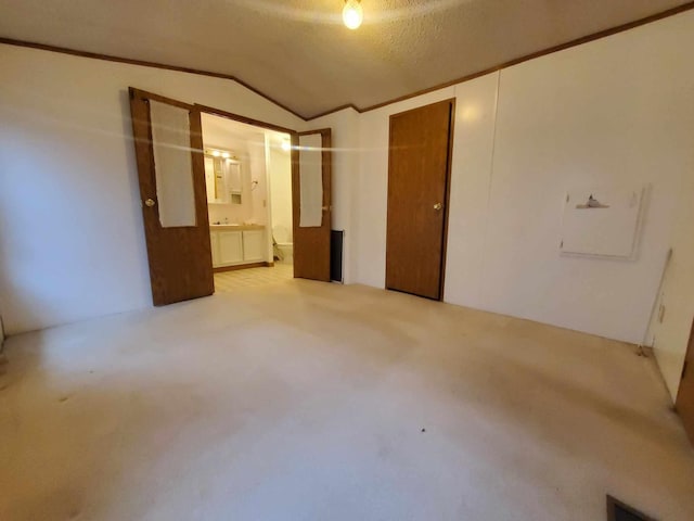 carpeted spare room with crown molding, lofted ceiling, and a textured ceiling