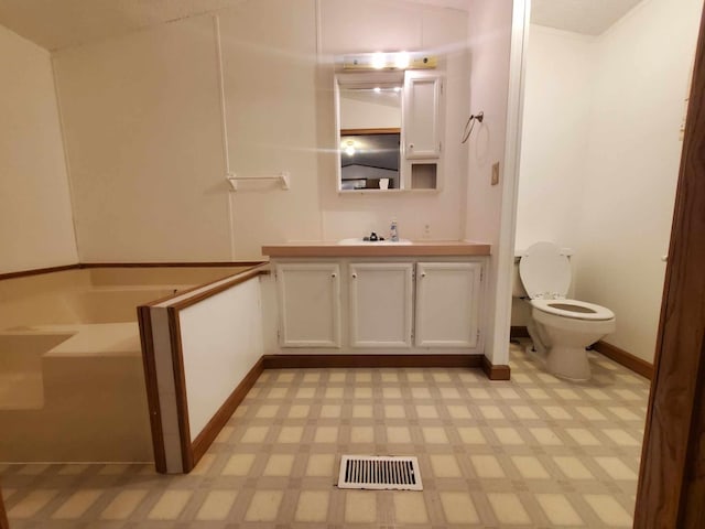 bathroom featuring vanity, toilet, and a tub