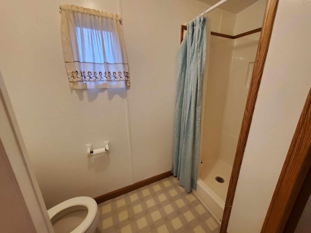 bathroom featuring curtained shower and toilet