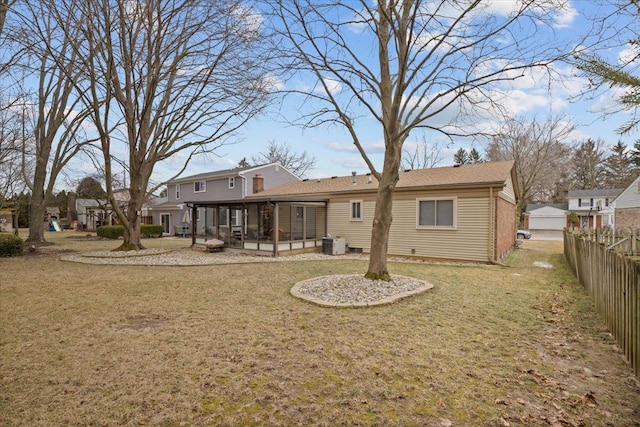 back of property with a sunroom, a yard, and central air condition unit