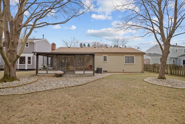 back of house featuring cooling unit, a sunroom, and a lawn