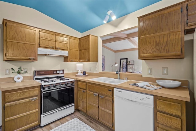 kitchen featuring vaulted ceiling, white appliances, sink, and light hardwood / wood-style flooring