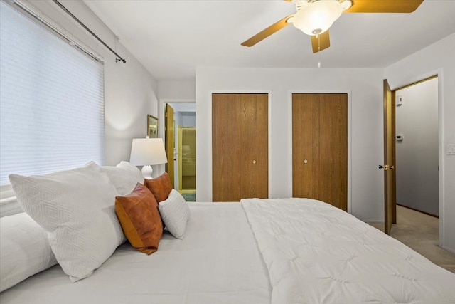 bedroom featuring two closets, carpet floors, and ceiling fan