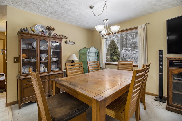 carpeted dining space featuring a textured ceiling and a chandelier