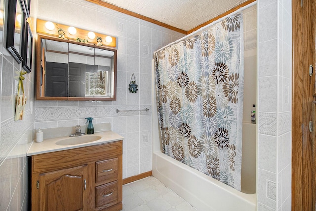 bathroom featuring tile walls, vanity, crown molding, shower / bathtub combination with curtain, and a textured ceiling