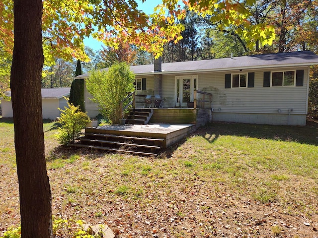 back of property featuring a deck and a lawn