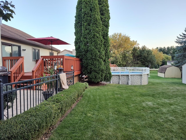 view of yard featuring a swimming pool side deck and a storage shed