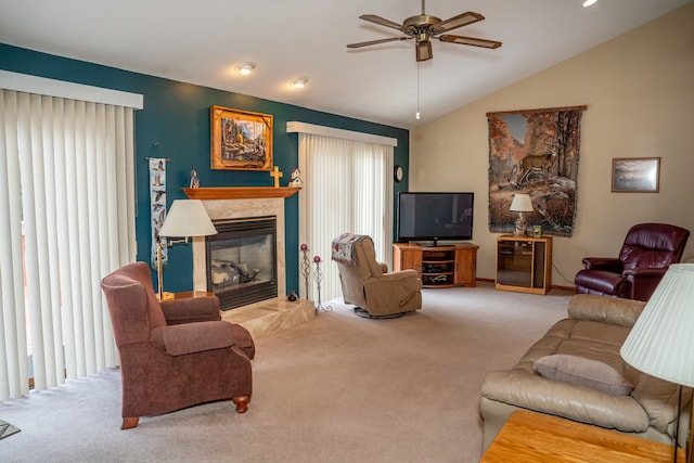 carpeted living room featuring a tile fireplace, lofted ceiling, and ceiling fan