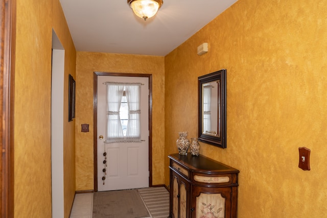 doorway to outside with light tile patterned flooring