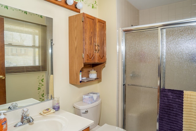 bathroom with vanity, toilet, and a shower with door