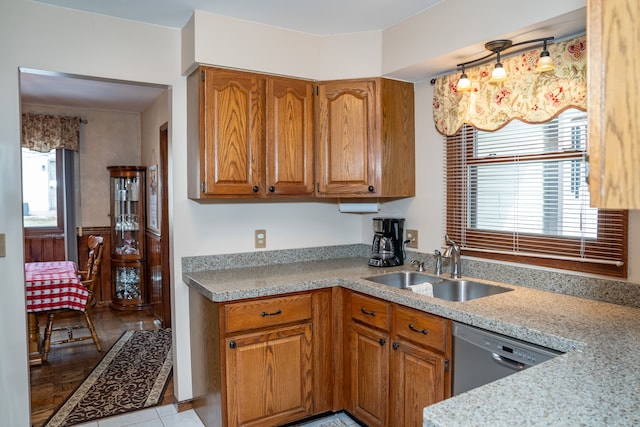 kitchen featuring dishwasher, sink, light stone countertops, and light tile patterned floors