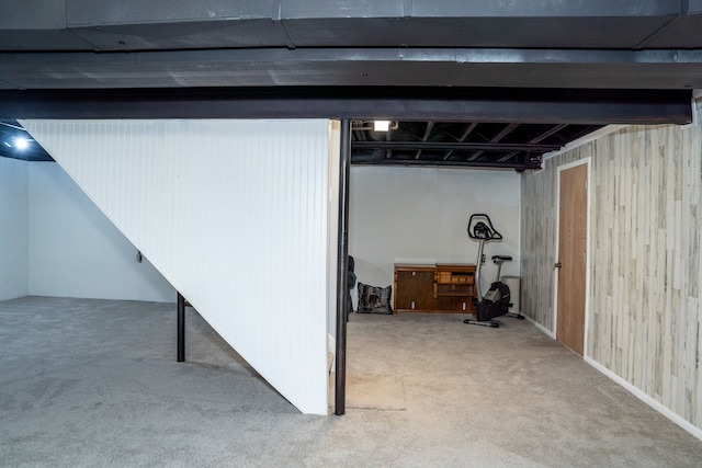 basement with carpet floors and wood walls