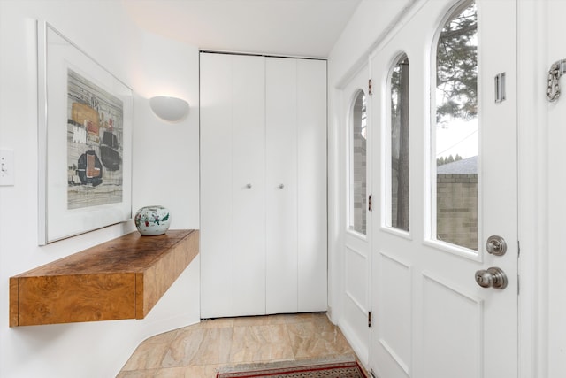 entryway featuring marble finish floor